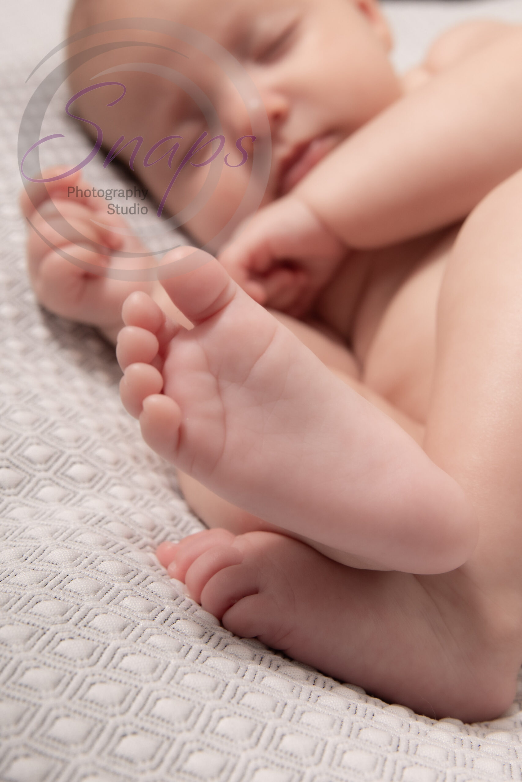 a newborns foot while the baby is sleeping on a grew bed