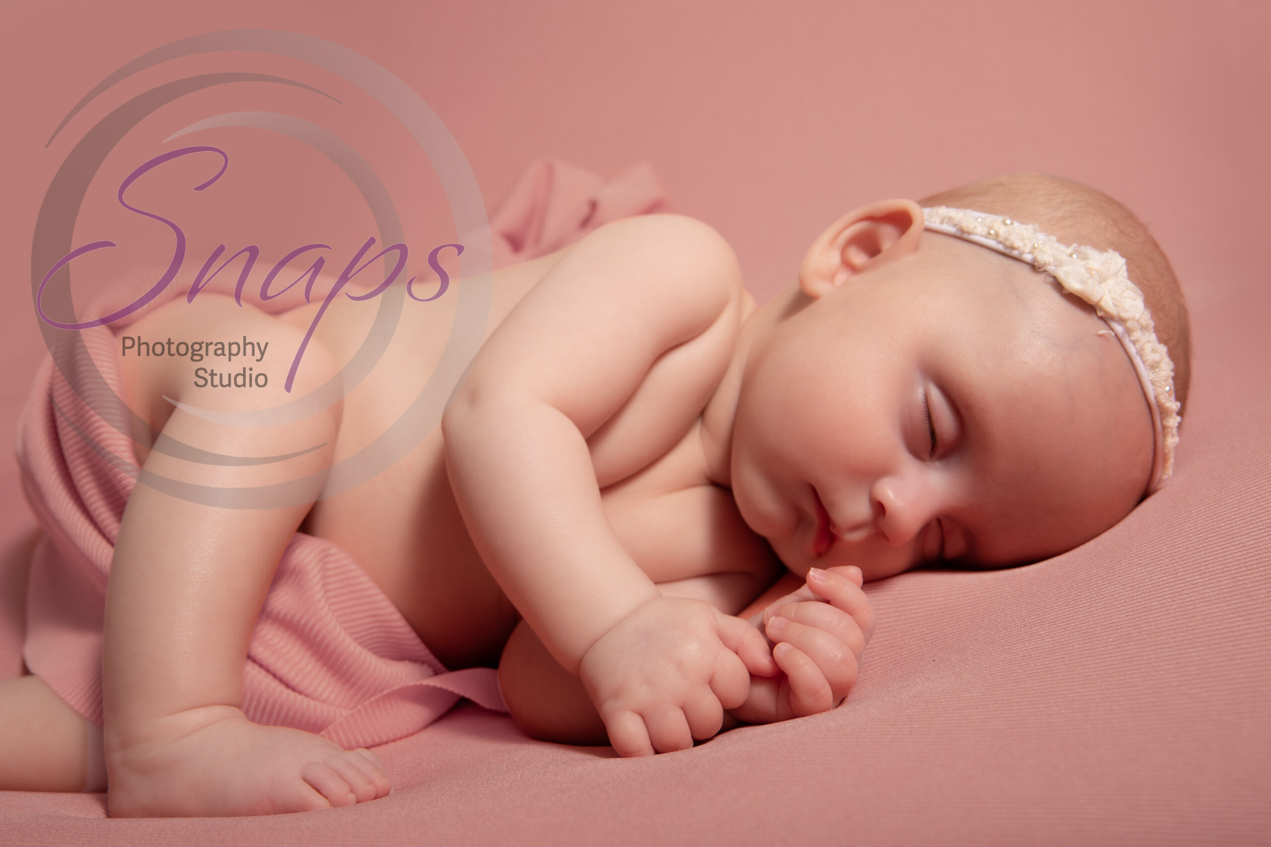Baby sleeping on a pink bed