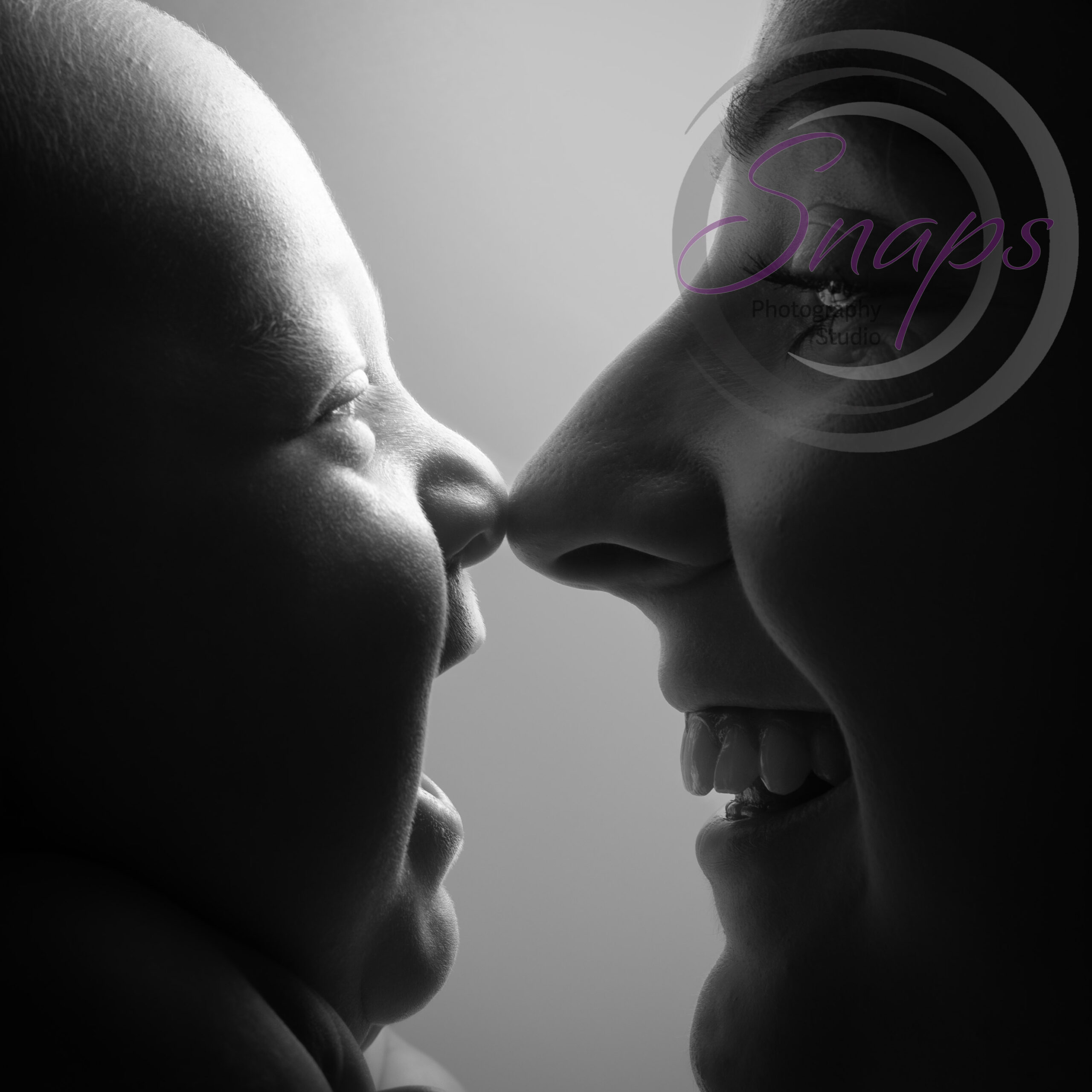 Black and white photo of baby and mummy nose to nose laughing