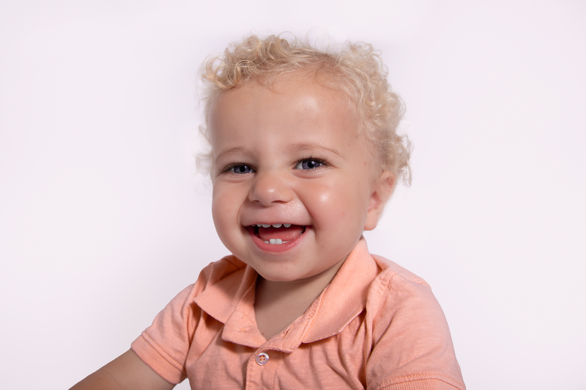 Smiling blond toddler having photoshoot in stroud