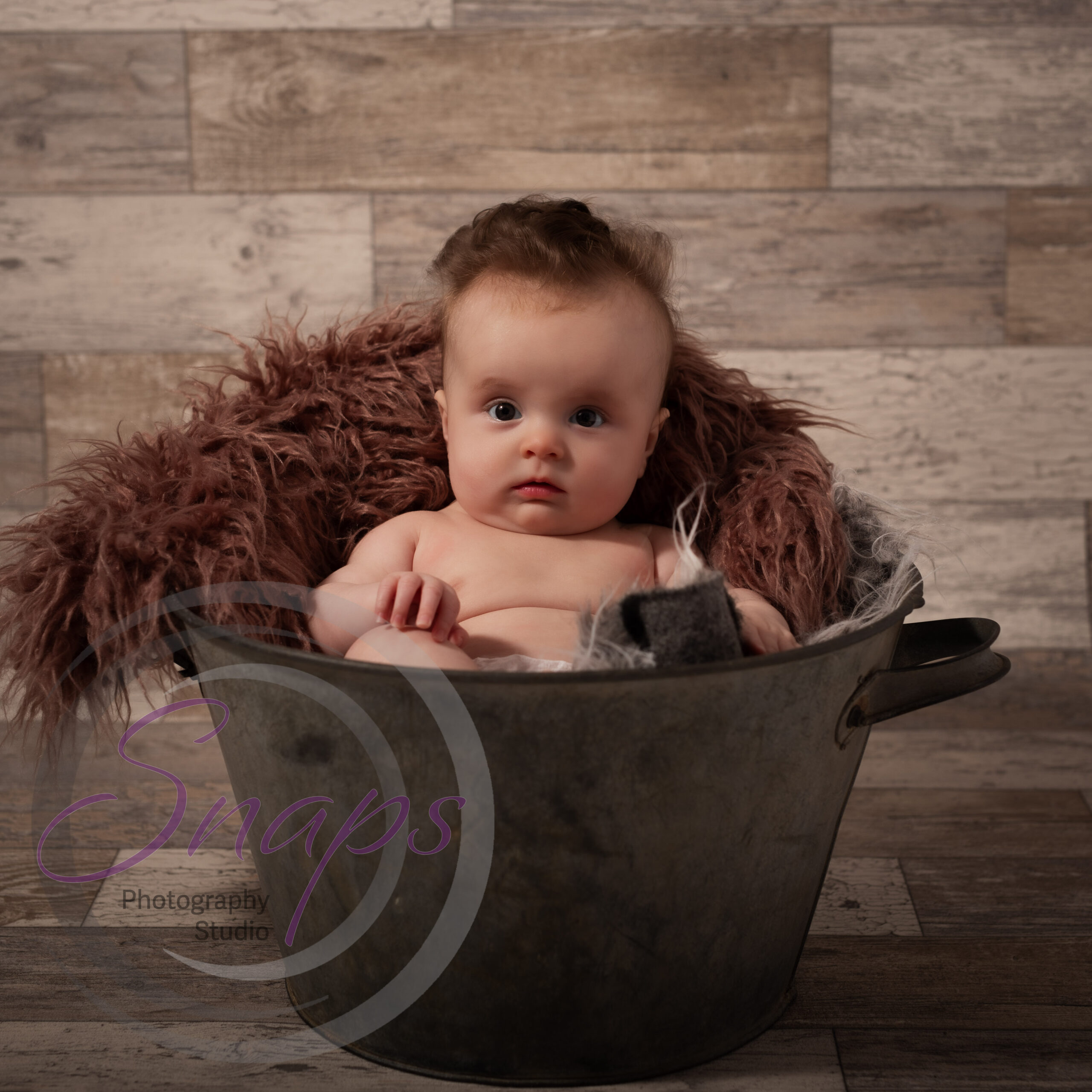 little girl in a metal bucket with pink fluff