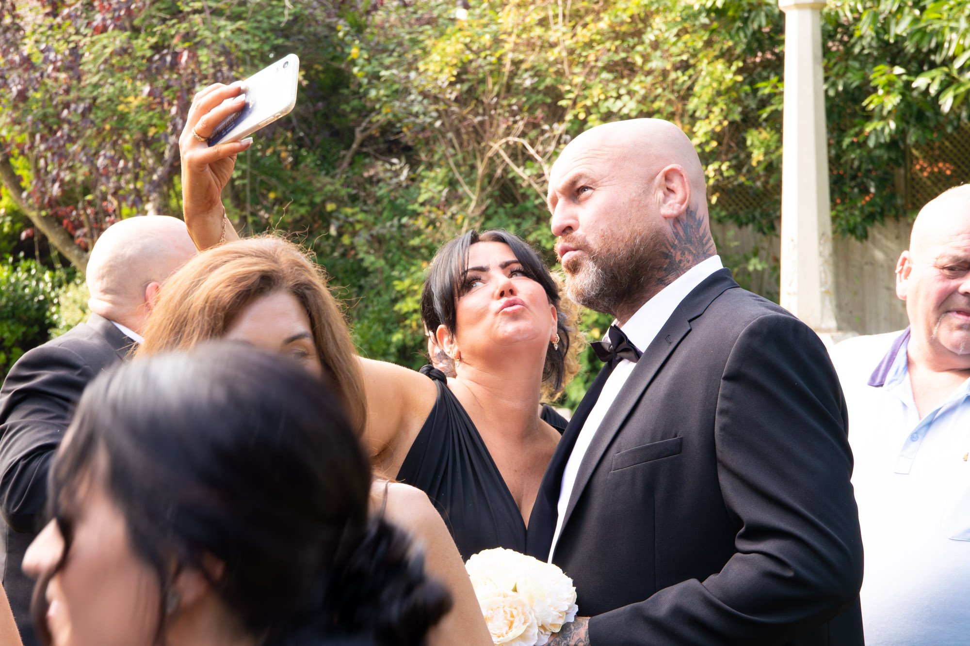 a couple taking a selfie at a wedding