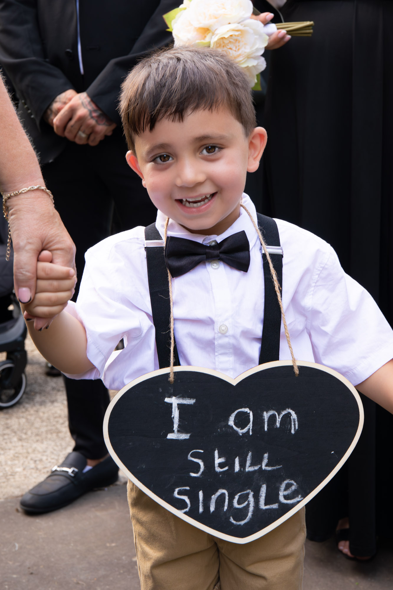 little boy with a sign saying I am still single at wedding